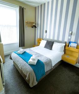 1 dormitorio con 1 cama grande y toallas. en The Berkeley Morecambe, en Morecambe