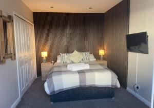 a bedroom with a bed with two lamps on it at The Annexe - Pagham in Pagham