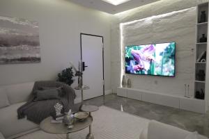 sala de estar con sofá y TV en la pared en شقه فندقيه فاخرة, en Riad