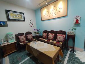 uma sala de estar com sofás e uma mesa com cadeiras em Qianshun Homestay em Xingang