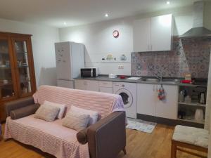 a living room with a couch and a kitchen at Apartamento Erillas in Pinos Genil