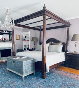 a bedroom with a canopy bed and a coffee table at 1000 Islands Bed and Breakfast-The Bulloch House in Gananoque