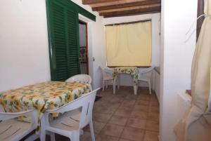a room with chairs and a table and a window at Appartamenti Seccheto in Seccheto