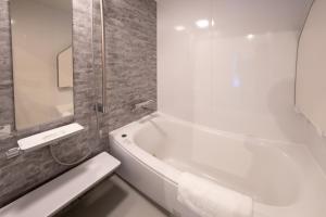 a bathroom with a white bath tub and a sink at Yuki Usagi - walking distance to Rusutsu Resort in Rusutsu +23 photos