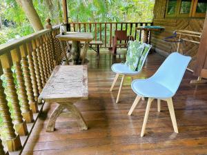 2 sillas azules y una mesa de madera en un porche en Chaweang cozy house 1 km.Lotus, en Ban Ko Khwan