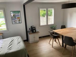 Cette chambre comprend un lit, une table et des chaises. dans l'établissement Appartement cosy, à Saint-Sébastien-sur-Loire