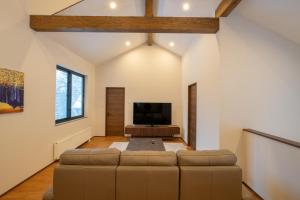 a living room with a couch and a flat screen tv at Yuki Usagi - walking distance to Rusutsu Resort in Rusutsu