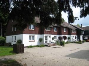 a large red and white house with a driveway at Ferienwohnung-am-Wurmberg-2 in Braunlage