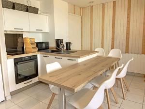 uma cozinha com uma mesa de madeira e cadeiras brancas em RÉF 383 - LORIENT Appartement duplex type 3 avec 2 parkings em Lorient