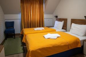 two beds in a hotel room with towels on them at Hotel Pepa in Divčibare
