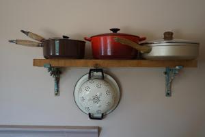 a shelf with pots and pans on a wall at Spiti Espede in Ágios Márkos