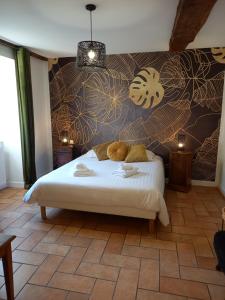 1 dormitorio con 1 cama con un mural en la pared en Hotel de la Halle, en Nolay