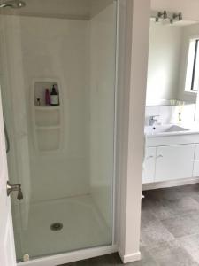 y baño con ducha y puerta de cristal. en City haven en Whanganui