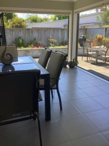 a dining room with a table and chairs on a patio at City haven in Whanganui