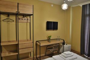 een slaapkamer met een bed, een bureau en een televisie bij Casa Del Mar in Kvariati