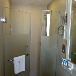 a bathroom with a shower with a glass door at Imperial Hotel Express in Kisumu