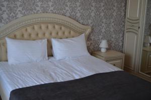 a bed with white sheets and pillows in a bedroom at Floros simfonija Jūros in Šventoji