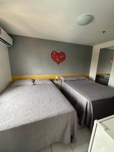 2 camas en una habitación con un corazón rojo en la pared en Flat no Condomínio Gran Lençóis-Barreirinhas - MA en Barreirinhas