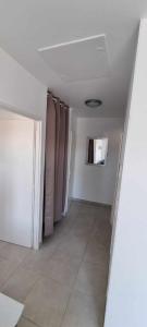 a room with a hallway with a door and a tile floor at Appartement neuf 39m2 avec balcon à 250m de la plage in Saint-Vincent-sur-Jard