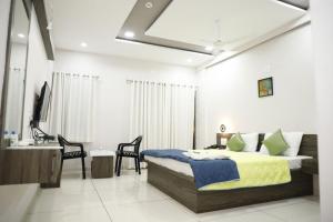 sypialnia z łóżkiem i umywalką w obiekcie Hotel Nilkanth Rooms & Restaurant , Halol w mieście Hālol