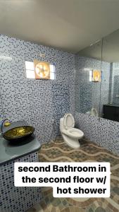 a bathroom with a toilet and a sink and a mirror at Heaven’s Gate Resort in Puerto Galera