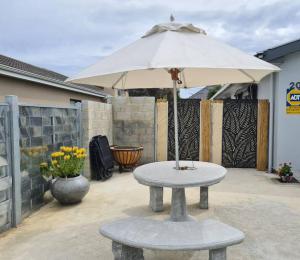 un tavolo con ombrellone su un patio di Elephant Lodge a Hermanus
