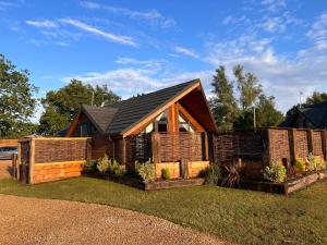 ein Haus mit einem Zaun davor in der Unterkunft Woodlakes Park By Liv Retreats in Kings Lynn