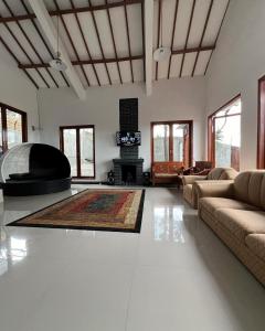 ein Wohnzimmer mit einem Sofa und einem Kamin in der Unterkunft Villa Kaki Bukit Ciwidey in Cisondari