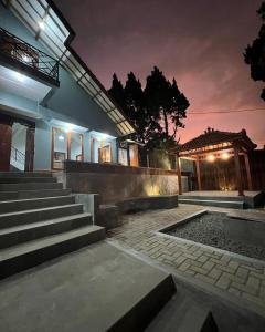 ein Haus mit einer Treppe, die nachts hinaufführt in der Unterkunft Villa Kaki Bukit Ciwidey in Cisondari