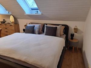 1 dormitorio con 1 cama blanca grande con almohadas en Ferienwohnungen Zur alten Dachdeckerei en Bad Bevensen