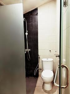a bathroom with a toilet and a shower at De Karanganjar Inn in Berni