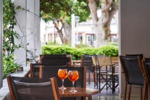 two wine glasses sitting on a table on a patio at Esperia City Hotel in Rhodes Town