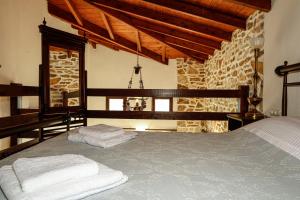 1 dormitorio con cama y pared de piedra en Annousa's House & Studios, en Kallirákhi
