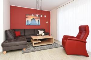 a living room with a couch and a chair and a table at Ferienhaus Antares - Uns Huus an t Küst in Bensersiel