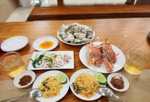 a wooden table with plates of food on it at Khách Sạn A68 in Vung Tau
