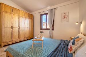 - une chambre avec un lit, des armoires en bois et une table dans l'établissement Luxury House San Teodoro Center, à San Teodoro