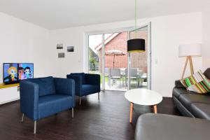 a living room with a couch and chairs and a table at Ferienhaus Goldbutt - Uns Huus an t Küst in Bensersiel