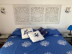 a bedroom with a blue bed with pillows on it at Dammuso Faraglione del Fico d'India in Pantelleria