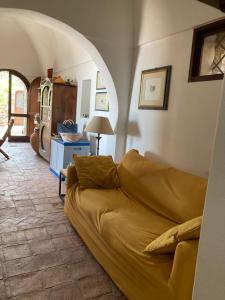 a living room with a couch and an archway at Dammuso Faraglione del Fico d'India in Pantelleria