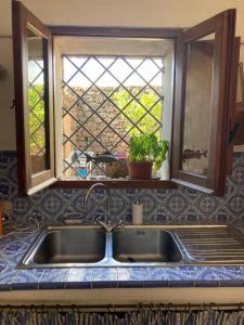 a sink in a kitchen with a window and a sink at Dammuso Faraglione del Fico d'India in Pantelleria +25 photos