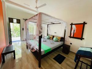 ein Schlafzimmer mit einem Himmelbett in der Unterkunft Pelli Riverine in Weligama