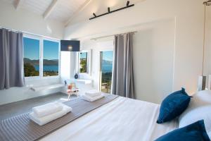 a bedroom with a large bed with a view of the ocean at VALAGRON VILLAS NIKIANA in Nikiana