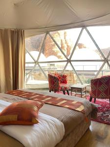 a bedroom with a bed and a large window at Toleen Camp wadi rum in Wadi Rum