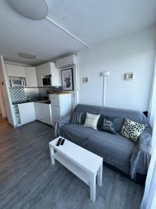 a living room with a couch and a coffee table at Studio vue port, parking privé, terrasse, clim in Le Grau-du-Roi