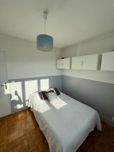 1 Schlafzimmer mit einem weißen Bett und einer blauen Decke in der Unterkunft Grande Maison, 10 mn stade JO in Rueil-Malmaison