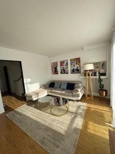 ein Wohnzimmer mit einem Sofa und einem Teppich in der Unterkunft Grande Maison, 10 mn stade JO in Rueil-Malmaison