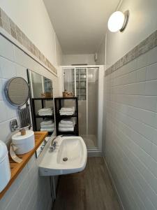 a white bathroom with a sink and a shower at Grande Maison, 10 mn stade JO in Rueil-Malmaison