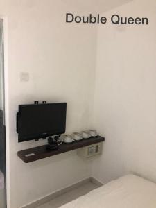 een tv aan een muur in een kamer bij Hotel Vistana Micassa in Taiping