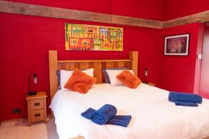 a bedroom with a large white bed with red walls at Jossie's Snug in Bletchingley