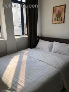 a bedroom with a large bed with a window at Hotel Vistana Micassa in Taiping
